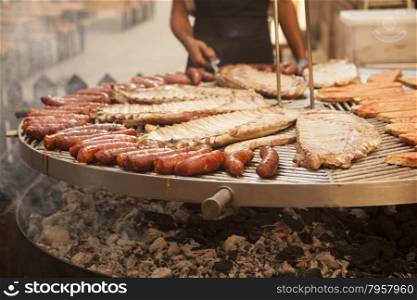 Gourmet meat pieces pork ribs, sausages,on a large grill in Spain.