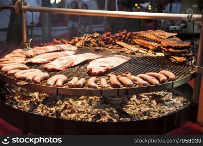 Gourmet meat pieces pork ribs, sausages,on a large grill in Spain.