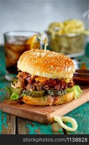Gourmet Pulled Pork Burger with with Coleslaw and barbecue Sauce on Wooden Table.