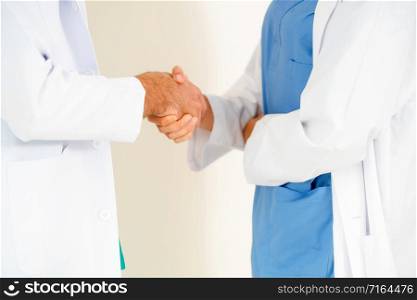 GP doctor shake hand with surgical doctor on white background.. GP doctor shakes hand with surgical doctor.