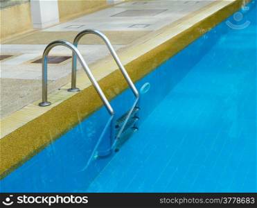 Grab bars ladder in swimming pool in daylight