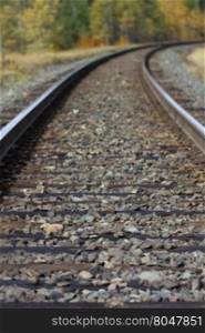 Graceful, metaphoric curve of railroad tracks with focus in foreground and unfocused distance representative of journey with unknowns ahead. Location is British Columbia, Canada, along Highway 16.