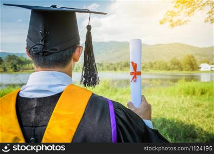 Graduate put he hands up and celebrating with certificate in he hand and feeling so happiness in Commencement day.