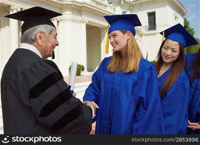 Graduate Shaking Hands and Receiving Diploma