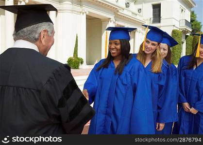 Graduate Shaking Hands and Receiving Diploma