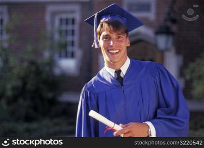 Graduate Smiling And Holding Diploma