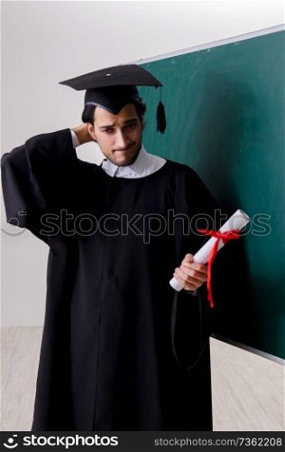 Graduate student in front of green board 