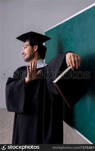 Graduate student in front of green board 