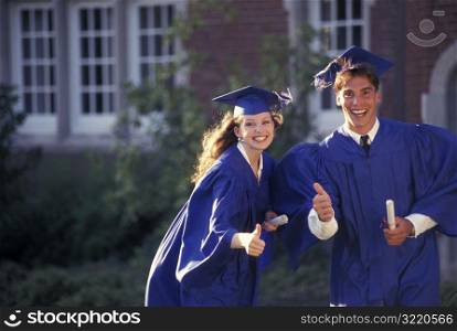 Graduates Giving Thumbs Up And Smiling