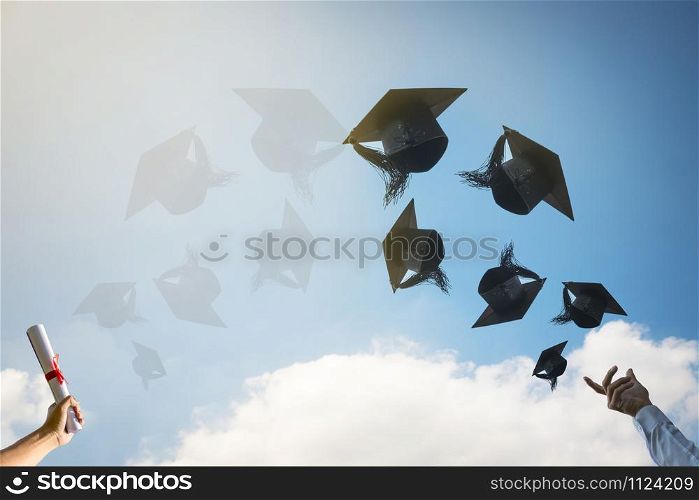 Graduates hands throwing graduation hats.