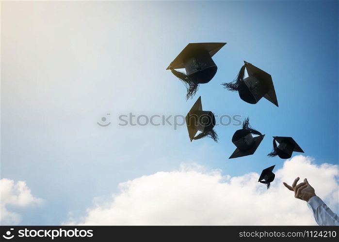 Graduates hands throwing graduation hats.