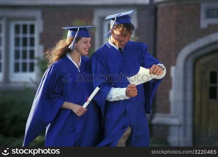 Graduates Looking At Diplomas