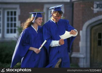 Graduates Looking At Diplomas