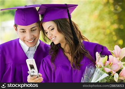 Graduates Using Cell Phone