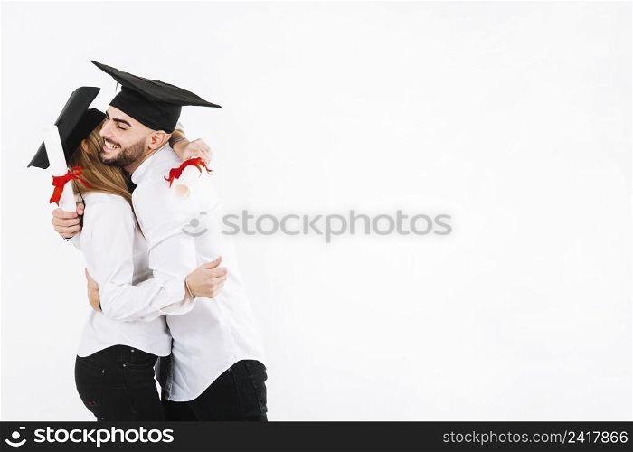 graduating couple embracing
