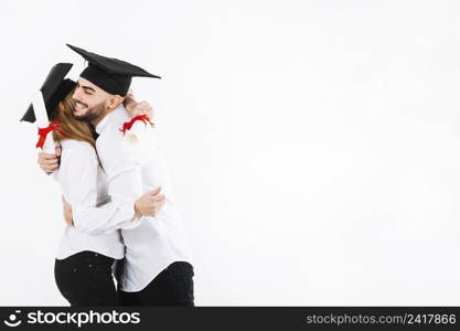 graduating couple embracing