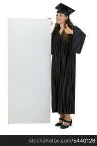 Graduation student holding blank billboard and showing thumbs up