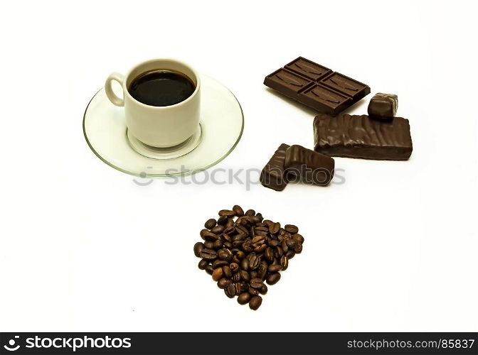 Grains of coffee, a cup of coffee, chocolate and chocolate candies on a white background
