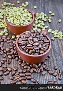 Grains of green and black coffee in brown clay cups and on a table on the background of a wooden board
