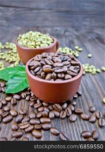 Grains of green and black coffee in brown clay cups and on a table with leaves on a wooden plank background