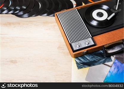 Gramophone with a vinyl records on wooden table, top view and copy space.