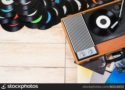 Gramophone with a vinyl records on wooden table, top view and copy space.