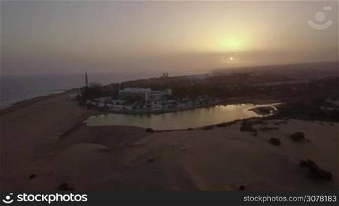 GRAN CANARIA, CANARY ISLANDS - AUGUST 02, 2016: Aerial view of resort area with hotels and houses on the ocean coast at sunset