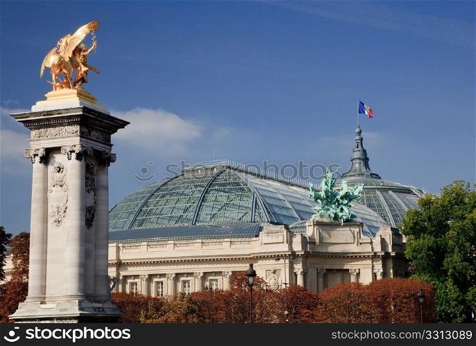 Grand Palais in Paris flanked by gold statues on the Pont de Alexandre III