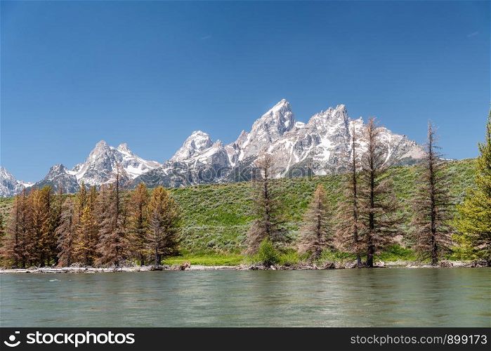 Grand Teton National Park mountain peaks as seen from a boat along Snake River, Wyoming.