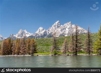 Grand Teton National Park mountain peaks as seen from a boat along Snake River, Wyoming.
