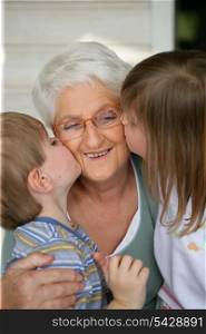 Grandchildren kissing grandma