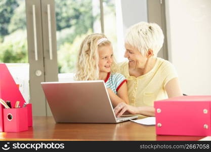 Granddaughter And Grandmother Using Laptop At Home