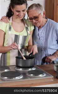 Granddaughter cooking for her grandmother