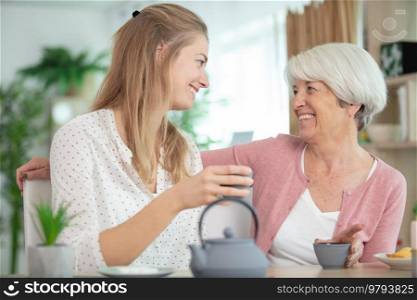 granddaughter visiting grandmother and having tea together
