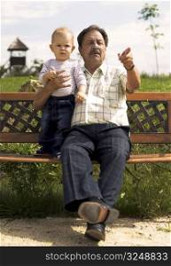 Grandfather and baby boy spend time together in the park.