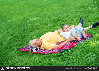 grandfather and child using tablet computer in park