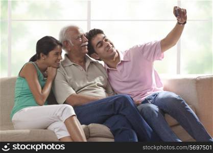 Grandfather and grandchildren taking a photograph of themselves