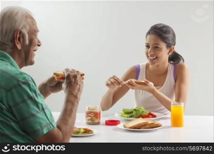 Grandfather and granddaughter eating breakfast