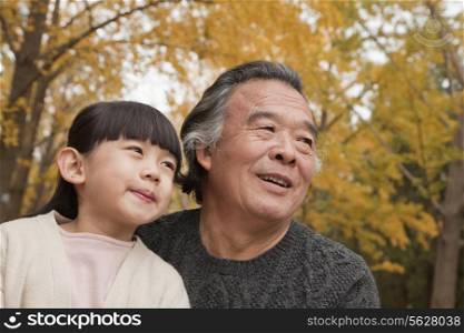 Grandfather and granddaughter in park