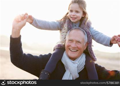 Grandfather And Granddaughter Walking On Winter Beach