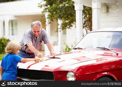 Grandfather And Grandson Cleaning Restored Classic Car