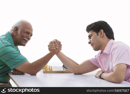 Grandfather and grandson doing arm wrestling