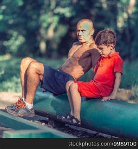 Grandfather and grandson doing sit-ups in park
