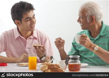 Grandfather and grandson eating breakfast