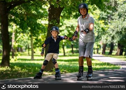 Grandfather and grandson enjoying roller skating in the park