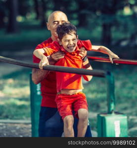 Grandfather and grandson  exercising in park