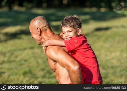 Grandfather and grandson  exercising in park