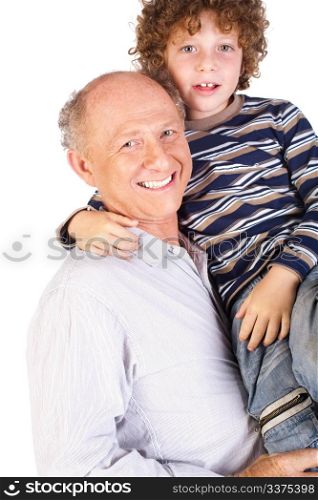 Grandfather and grandson indoors smiling.