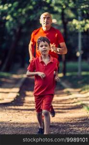 Grandfather and grandson jogging in park