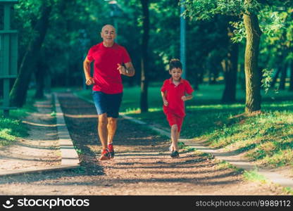 Grandfather and grandson jogging in park